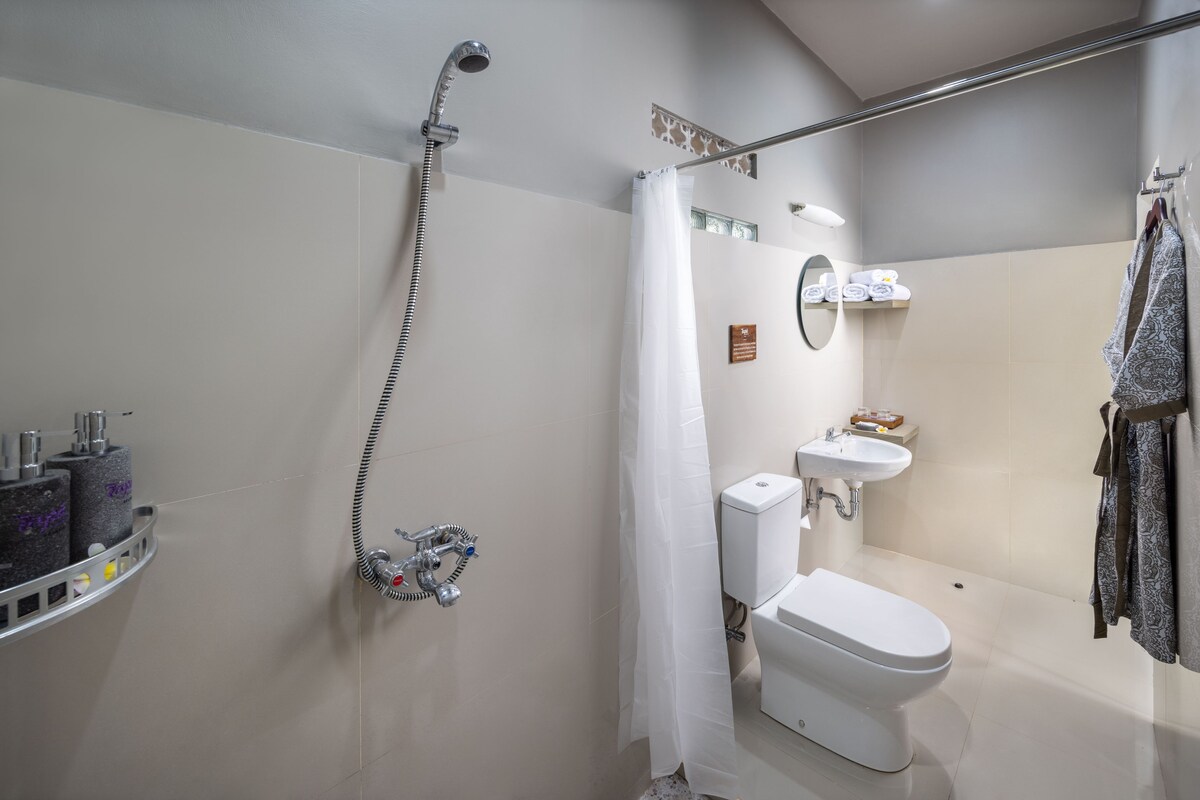 A modern bathroom with a shower, toilet, sink, and towel rack.