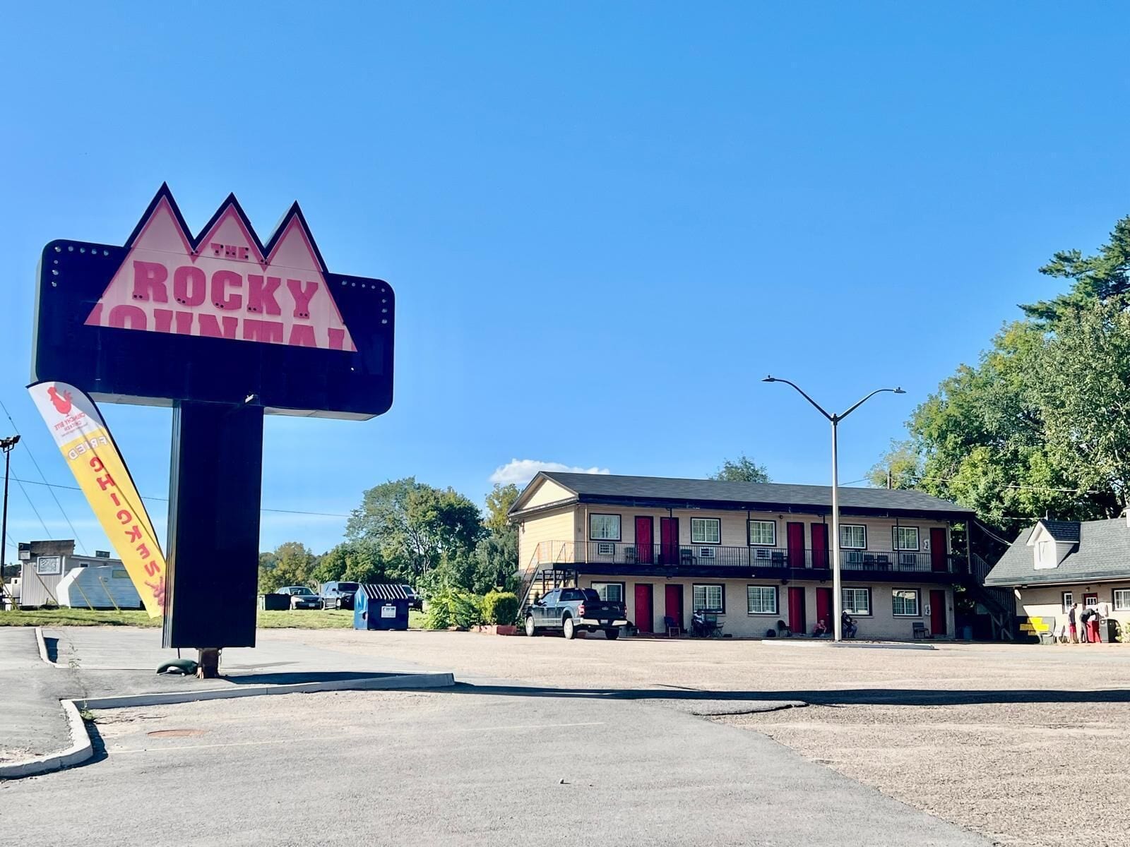 Un motel con un letrero de neón grande que dice "The Rocky Mountain".