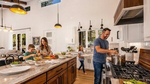 Una cucina moderna con mobili in legno, un piano di lavoro in marmo e una grande isola.