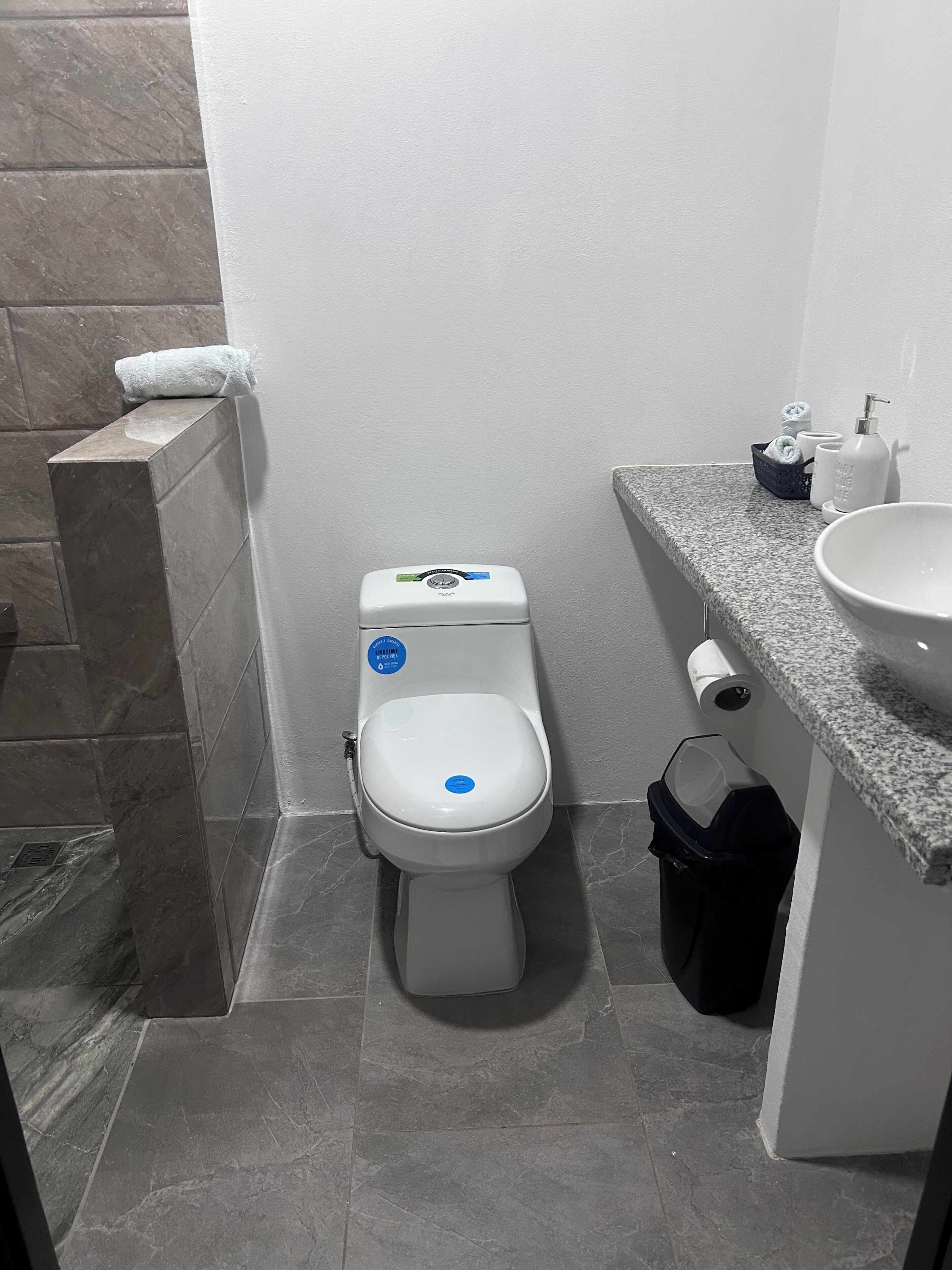 Ein Badezimmer mit Toilette, Waschbecken und Handtuchspender.
