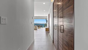 A modern hallway with a view to a balcony, a wooden wall, and a minimalist design. - Panarea 3D | Beachfront 4BR + Ocean Views & Pools (Bucerías)