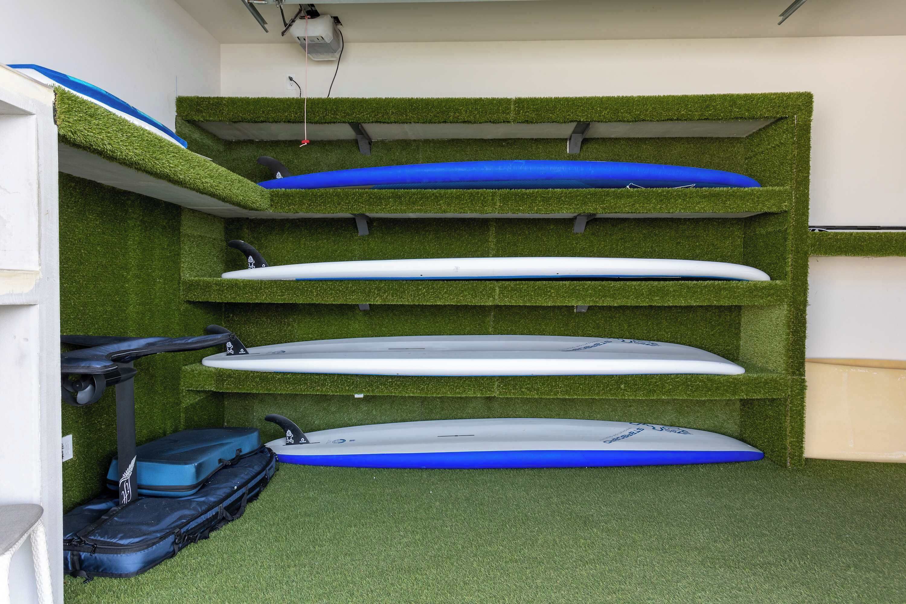 A room with a green artificial turf floor, white walls, and a ceiling with a light fixture.