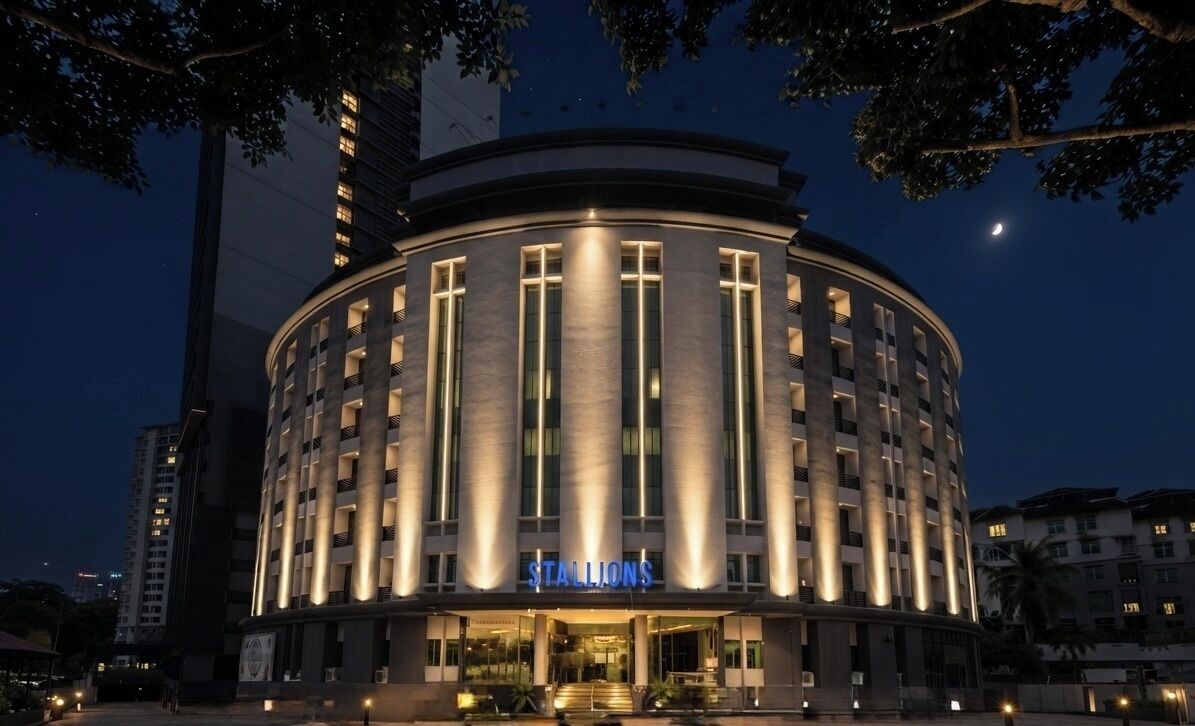 A hotel with a circular facade, illuminated windows, and a visible entrance.