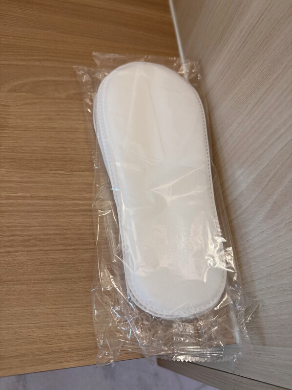 A white object in a clear plastic bag on a wooden surface. - Stallions Suite Penang (George Town)
