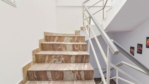 Un escalier avec des marches en marbre et une rampe en métal.