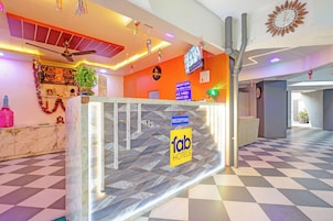 A hotel reception area with a check-in counter, a reception desk, and a clock on the wall.
