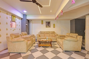 A living room with a checkered floor, beige sofas, a coffee table, and a ceiling fan.