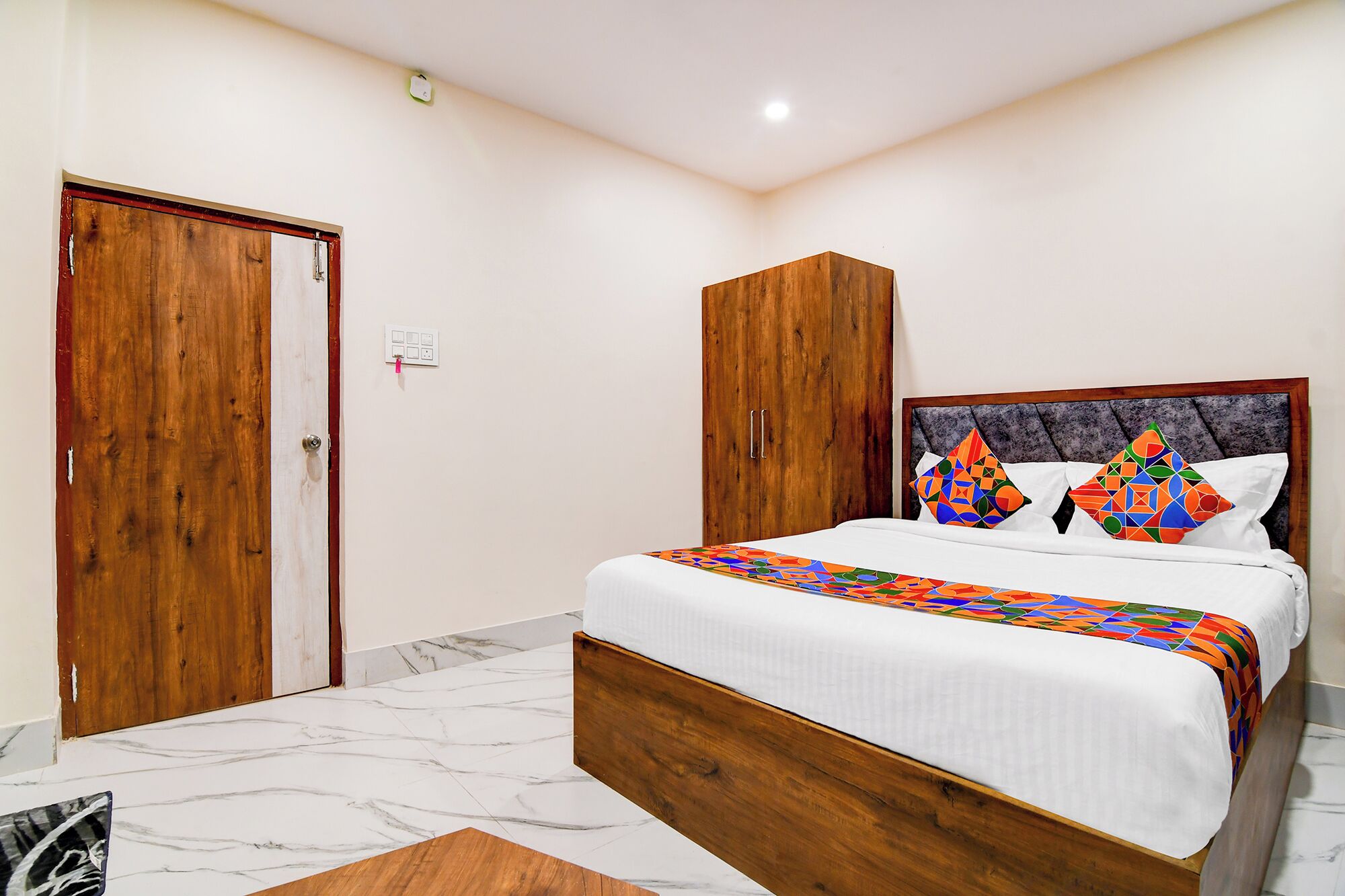 Un dormitorio con cama, armario de madera y suelo de mármol.