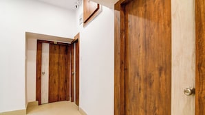 Un pasillo con puertas de madera y suelo de baldosas.