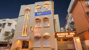 Un edificio con un letrero que dice 'fabHOTELS' y otro que dice 'ADHIRAJ INN GUEST HOUSE'.