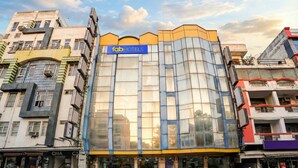 A modern building with a 'fabHOTELS' sign, featuring a glass facade and a yellow accent on the top. - Fabhotel Shivdev International (New Delhi)