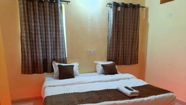 A single bed with a white mattress and brown headboard, two pillows, and a blanket. - Via Comfort Hub (Hingna)