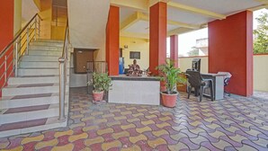 A lobby with a staircase, a reception desk, and potted plants. - Via Comfort Hub (Hingna)