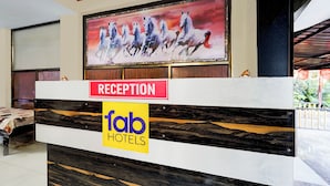 A reception desk with a 'Reception' sign and 'Fab Hotels' logo. - Via Seven Hills Inn (Mawal)