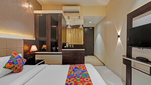 A hotel room with a bed, a desk, a TV, and a bathroom visible through a glass door. - Fabhotel Kv (Pen)