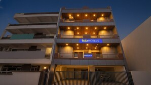 Un hôtel à plusieurs étages au design moderne, doté de balcons à chaque niveau et d’une enseigne « fabHOTELS » bien visible.