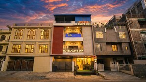 A hotel with a modern facade, a prominent sign for 'Hotel Olive Inn', and a visible entrance with a gated driveway. - Fabhotel Olive Inn (Indore)