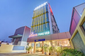 A hotel with a modern facade, a sign for 'AYODHYA PURE VEG', and a 'FOTOHOTELS' sign. - Fabhotel Ayodhya (Rajgurunagar)