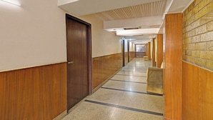 Un pasillo largo y estrecho con paneles de madera en las paredes y suelo de baldosas.