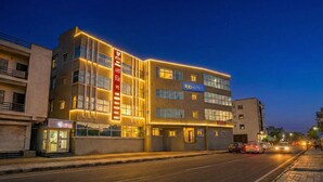 A multi-story hotel with a prominent sign for 'fabHOTELS' and a vertical sign with text in a non-Latin script. - Fabhotel Pearl Inn (Rajgurunagar)