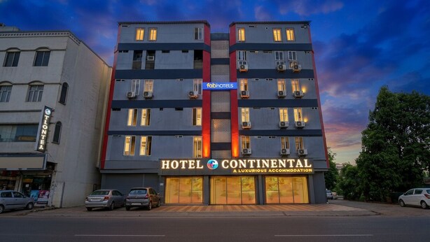 Ett hotell med flera våningar, med en framträdande skylt som lyder: ”HOTEL CONTINENTAL – LYXIGT BOENDE”.