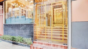 A hotel entrance with a glass facade, a marble reception desk, and a staircase leading inside. - Fabhotel Raj Niwas (New Delhi)