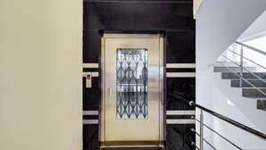 A modern elevator with a metallic door and a digital display.