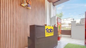 A hotel entrance with a wooden facade, a yellow sign reading "fab hotels", and a red gate. - Fabhotel Swastik Villa (Varanasi)