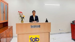 A reception desk with a sign reading "RECEPTION" and a logo for "fab hotels". - Fabhotel Sarala Residency (Noida)