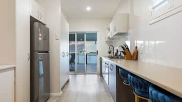 Geladeira, fogão, cooktop, mesas de jantar