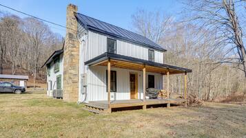 A modern house with a stone chimney, a covered porch, and a garage.