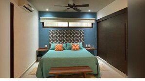 A bedroom with a bed, a ceiling fan, an air conditioning unit, and a dark-colored wardrobe. - Wonderful 1-bedroom apartment with AC in vibrant Tulum (Tulum)