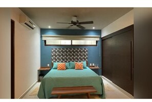 A bedroom with a bed, a ceiling fan, an air conditioning unit, and a dark-colored wardrobe. - Wonderful 1-bedroom apartment with AC in vibrant Tulum (Tulum)
