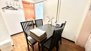 Ein Essbereich mit Tisch, Stühlen und einer Blumenvase.
