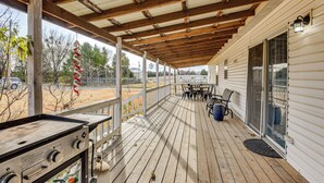 A covered porch with a grill, outdoor seating, and a view of the surrounding area. - Steps to Lake Eufaula: Family Home w/ Deck & Yard (Eufaula)