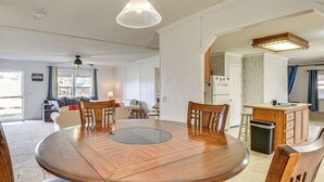 A modern kitchen with a wooden dining table, chairs, and a built-in island with a sink. - Steps to Lake Eufaula: Family Home w/ Deck & Yard (Eufaula)