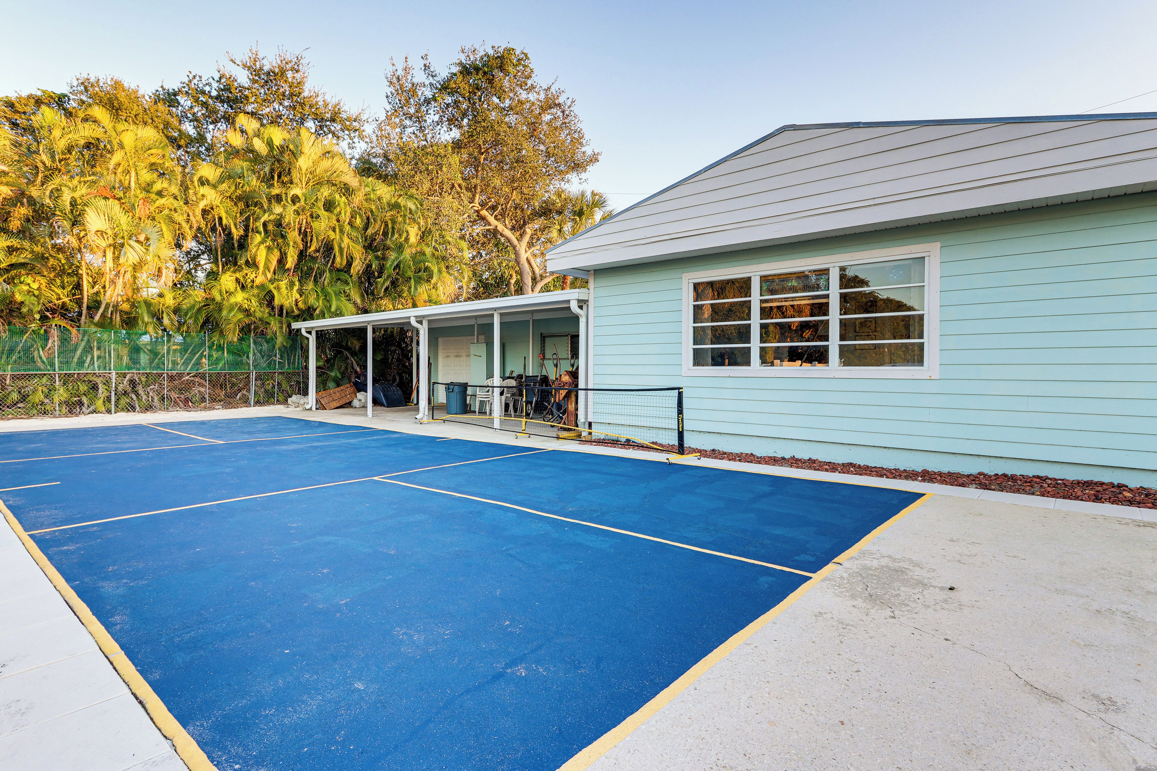 Un campo da tennis vicino a un edificio con un portico coperto.