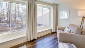 A room with a large window, a sofa, a lamp, and a rug. - Waterfront Home on Greers Ferry Lake w/ Game Room (Edgemont)