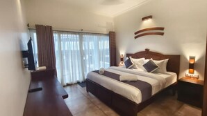 Habitación de hotel con una cama grande, un escritorio y una televisión.