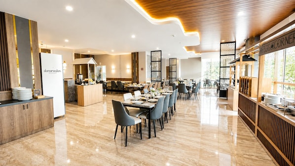 A modern restaurant interior with a long dining area, a counter with a menu, and a kitchen in the background. - Azana Style Hotel Jombang (Peterongan)