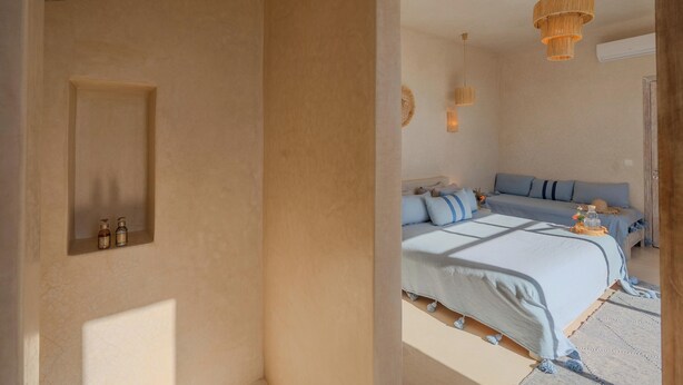 Una camera da letto con un letto grande, un comodino e una mensola a parete con delle bottiglie.