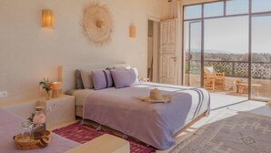 Una camera da letto con un letto grande, un balcone con vista e un arredamento in stile rustico.