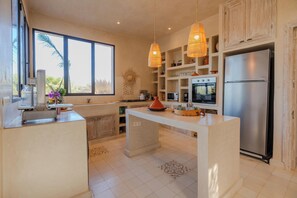 A modern kitchen with a central island, stainless steel appliances, and pendant lighting. - Lalla Essaouira - Villa Koulchi, 10 bedroom, until 28 peop with staff (Essaouira)