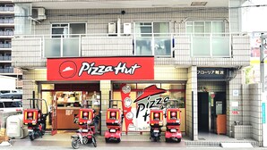 Un immeuble à plusieurs étages qui abrite un restaurant Pizza Hut au rez-de-chaussée.