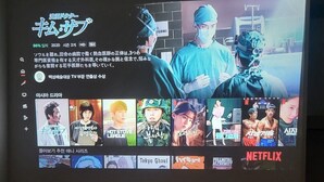 Un écran de télévision affiche l’interface d’un service de diffusion en continu, avec différentes vignettes de films et le logo de Netflix bien visible.