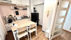 Une cuisine de taille réduite, avec une table et des chaises en bois, un four à micro-ondes et une cuisinière.