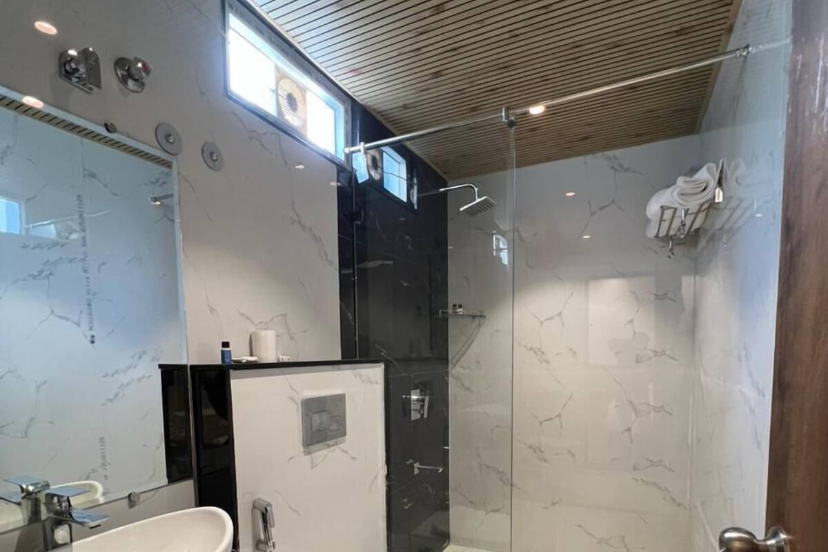 A modern bathroom with a large sink, toilet, and glass-enclosed shower.