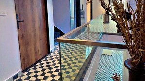 Un vestíbulo de hotel con piso a cuadros, barandilla de vidrio y tragaluces.