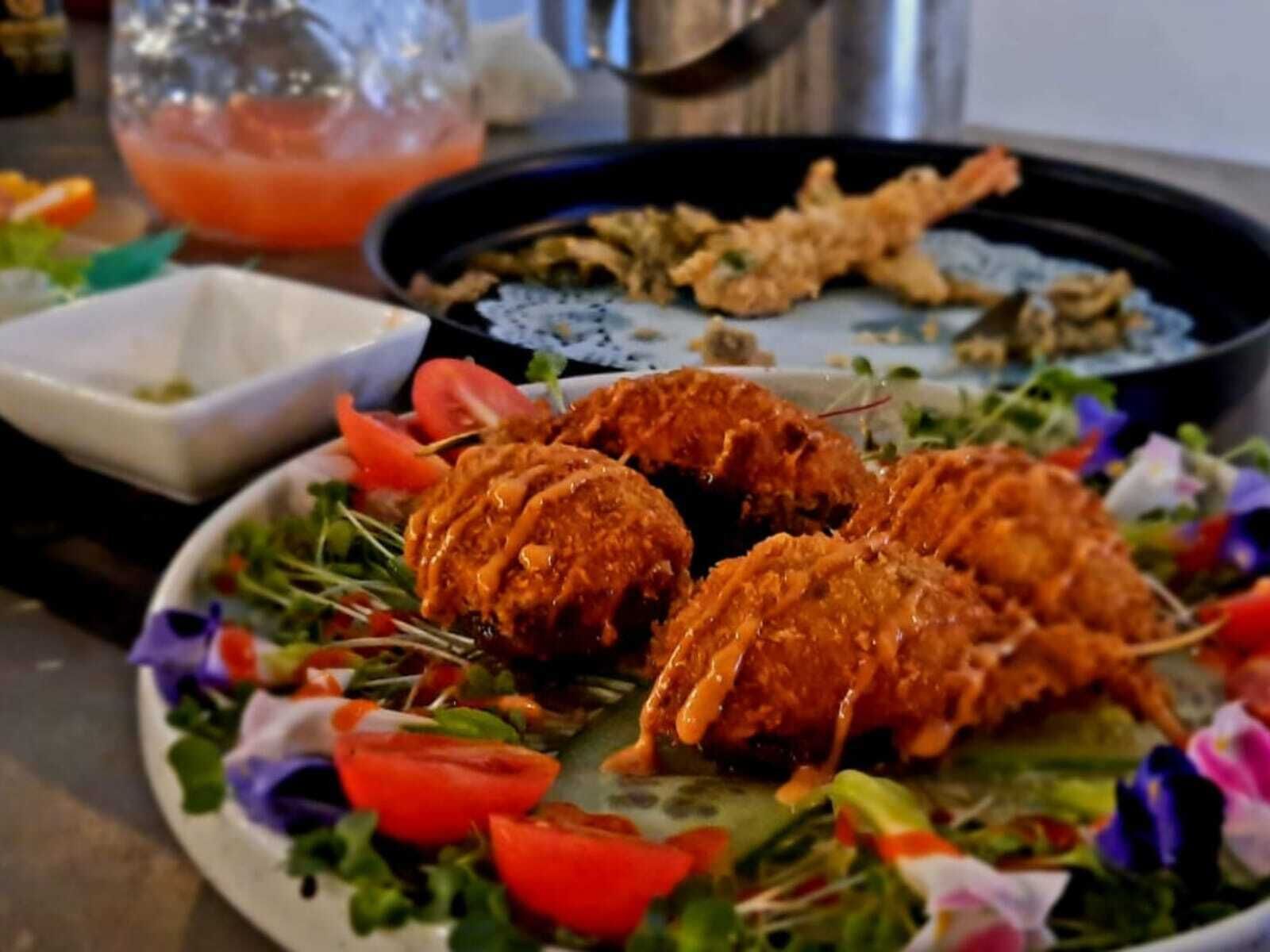 Une assiette de nourriture, avec une salade et un bol de sauce.