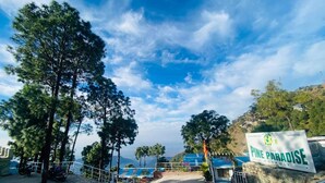 A sign for "The Pine Paradise" hotel with a view of the surrounding landscape. - The Pine Paradise (Kasauli)
